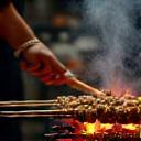 Chef grilling kebabs over charcoal